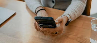 Teléfono con una aplicación de finanzas personales mostrando el registro de gastos con fotografías de recibos