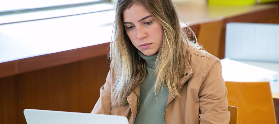 Estudiante con una computadora portátil tomando un curso en línea de University of the People